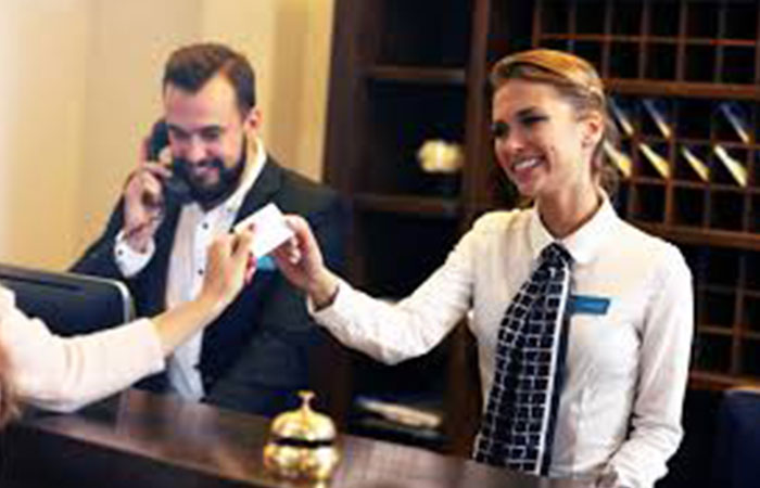 ホテル受付カウンターで働く女性と電話をする男性 - ホテルインターンのイメージ図